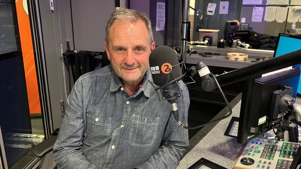 BBC broadcaster Mark Radcliffe sat in front of the microphone in the BBC Radio 2 studio.