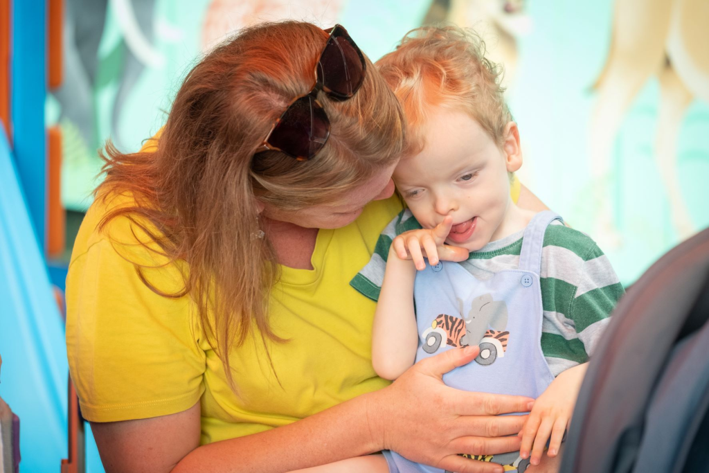Adult holding and comforting a young child, sharing a gentle moment together.