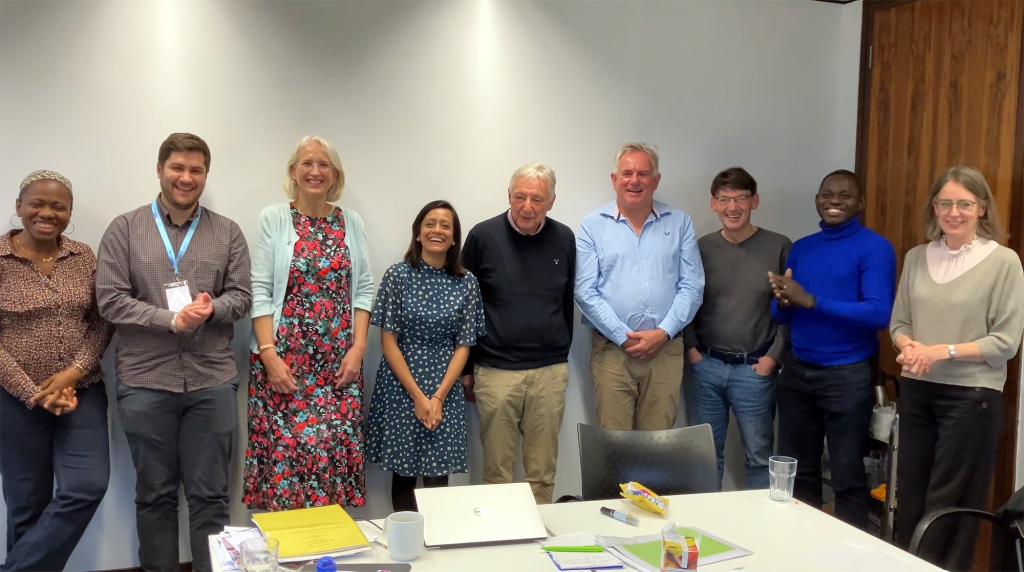 Music in Hospitals & Care trustees standing together and smiling during a team meeting.