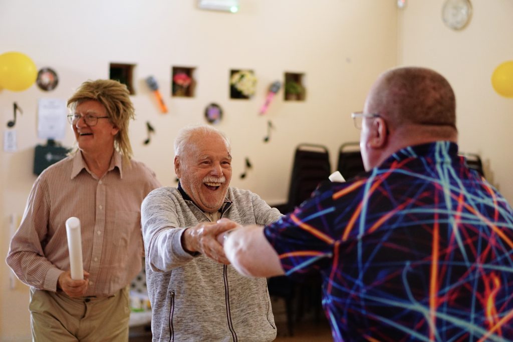 Musician performing for residents during the 75th anniversary of a ‘Friendship Cabin’ community music event organised by Music in Hospitals & Care