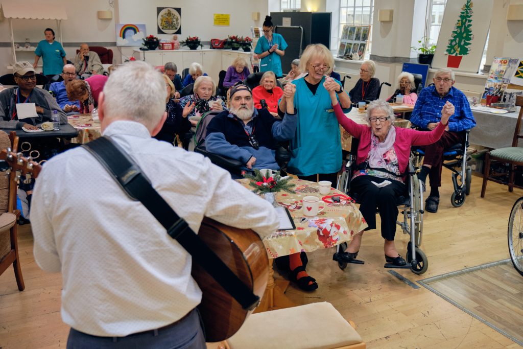 Guitarist playing to group at St Davids home